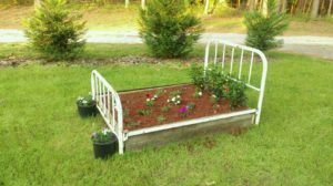 flowers planted in an old metal bed frame
